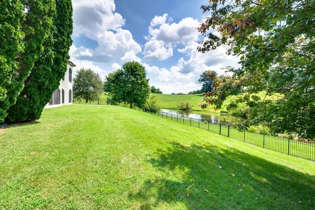 a front view of a house with a garden and trees