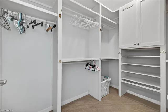 a view of walk in closet with clothes and shoes