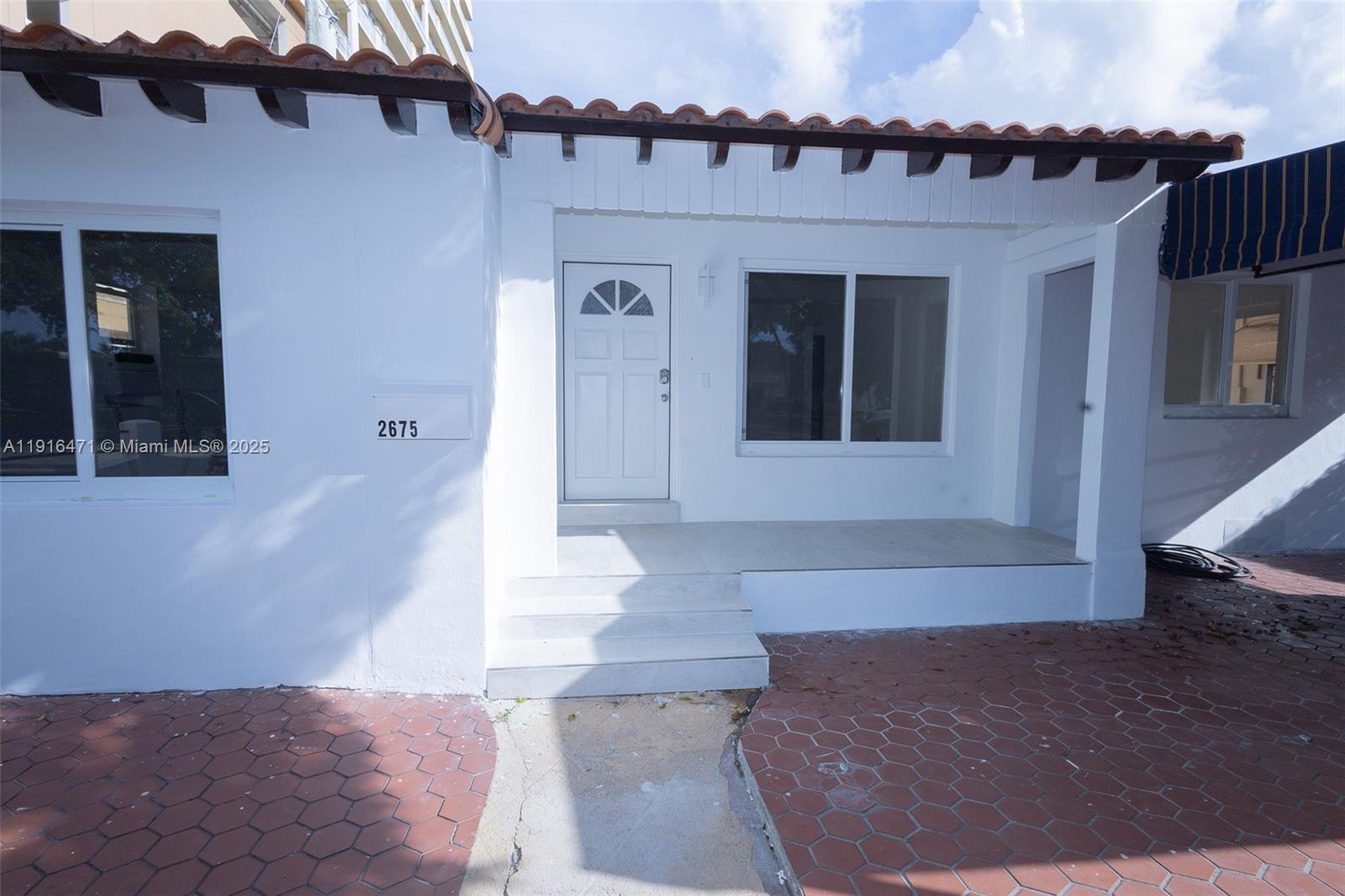 2675 Southwest 24th Terrace Miami, FL 33145 - Photo 5 of 36 a front view of a house with a yard and garage