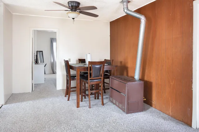 a dining room with furniture and a chandelier fan