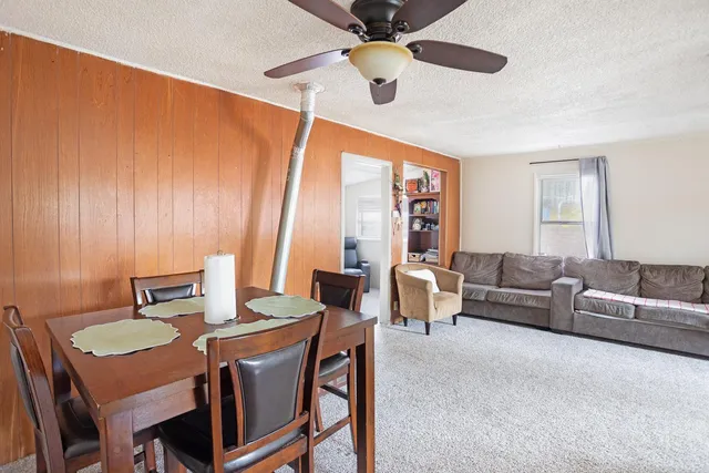 a living room with furniture a ceiling fan and a window