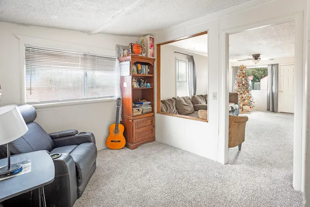 a living room with furniture and view of kitchen