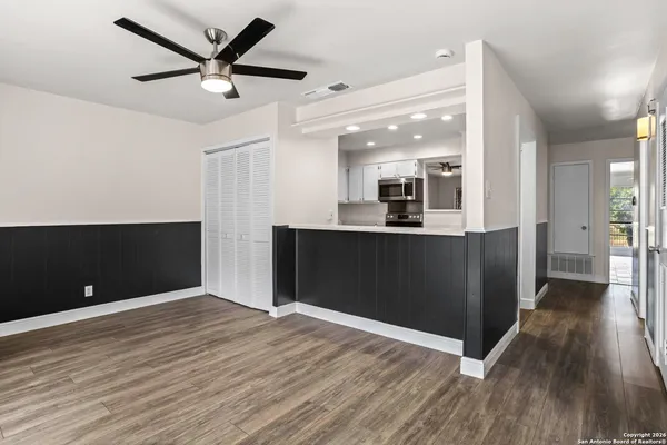 a view of a big room with wooden floor and a ceiling fan