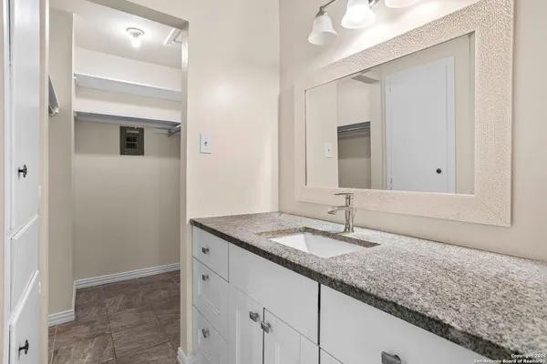 a bathroom with a granite countertop sink and a mirror