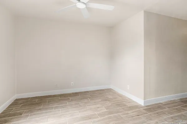 a view of an empty room with wooden floor