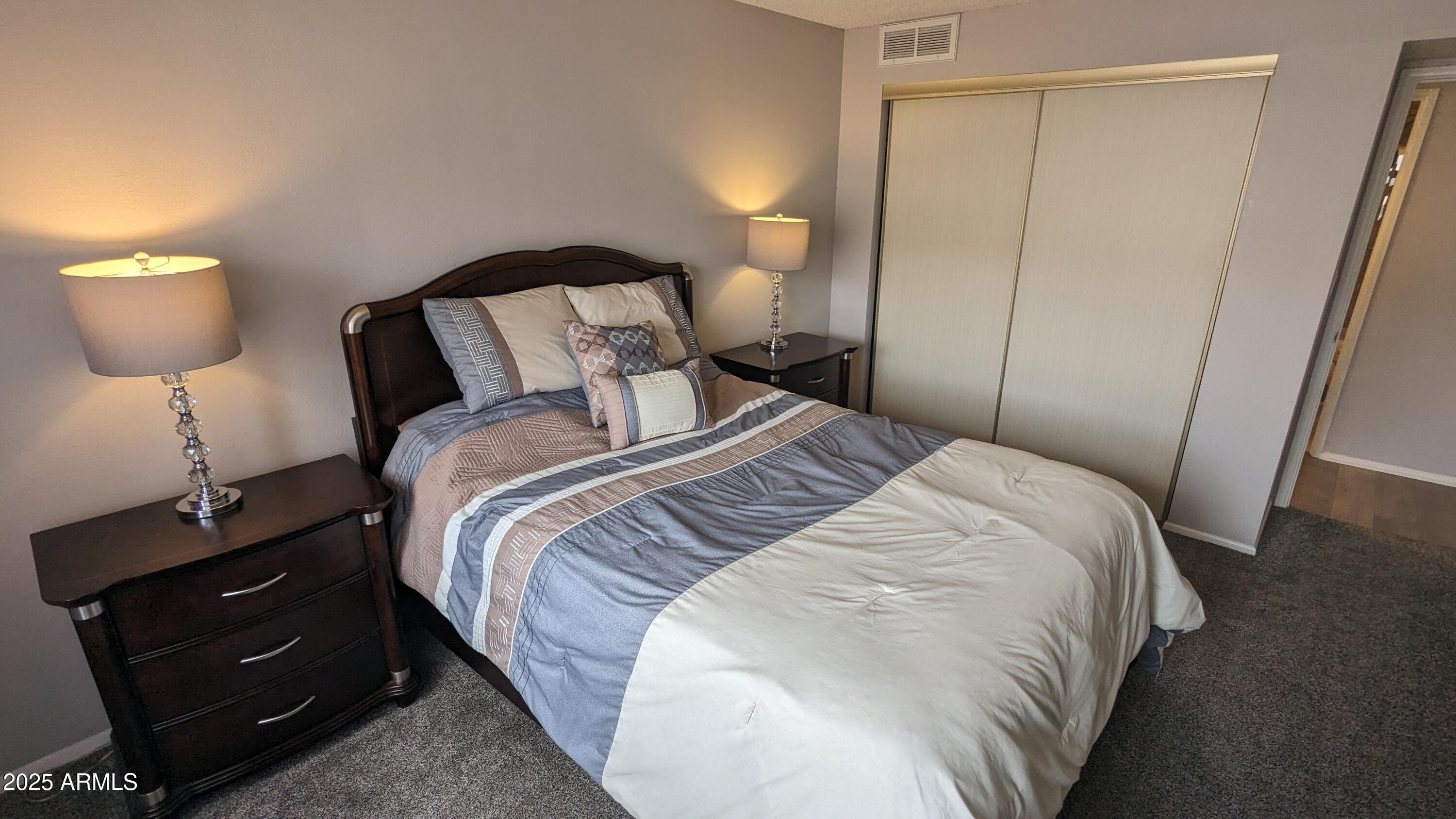 7910 East Camelback Road, Unit 302 Scottsdale, AZ 85251 - Photo 13 of 26 a bedroom with a bed and a lamp