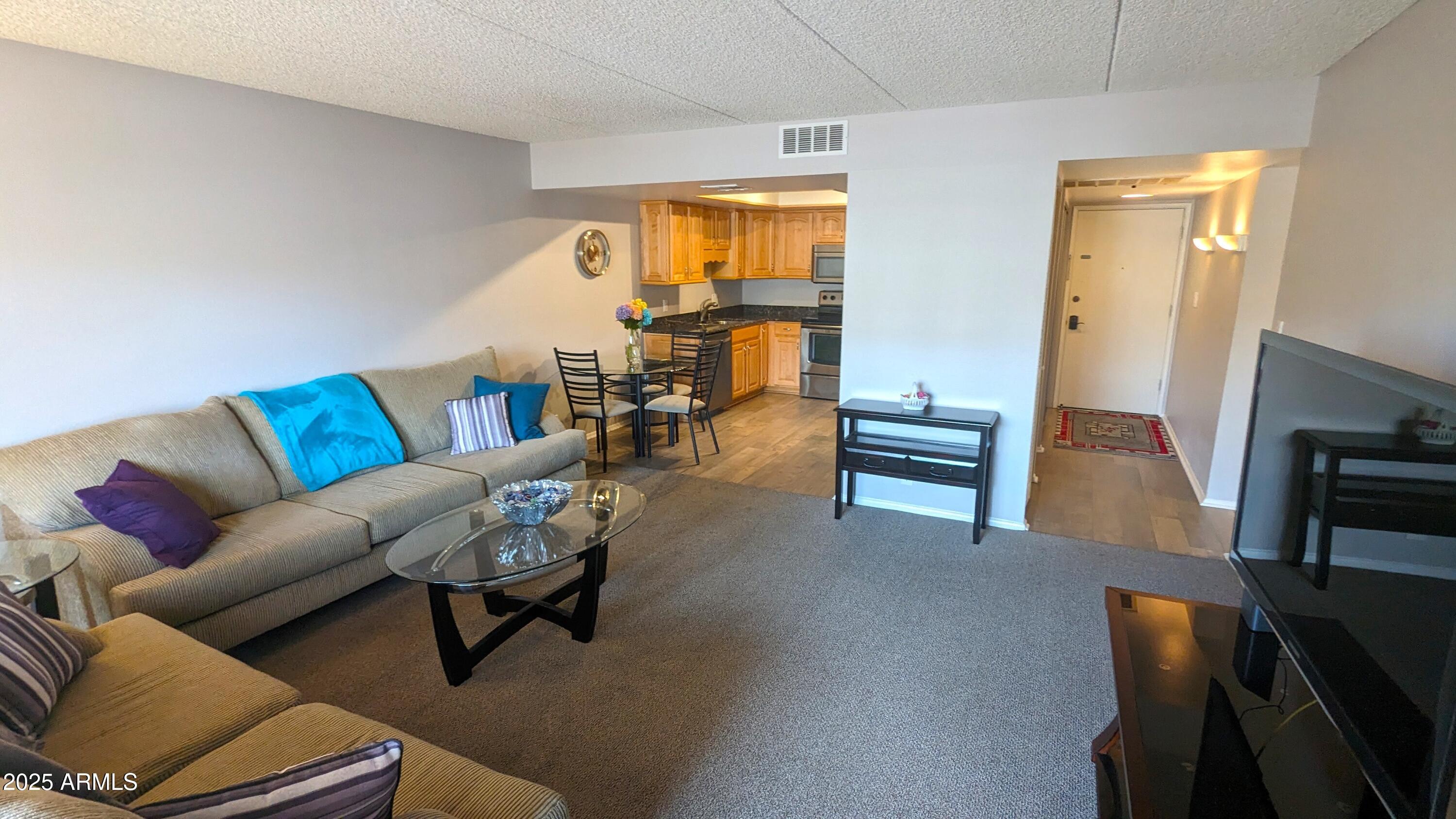 7910 East Camelback Road, Unit 302 Scottsdale, AZ 85251 - Photo 5 of 26 a living room with furniture and a flat screen tv