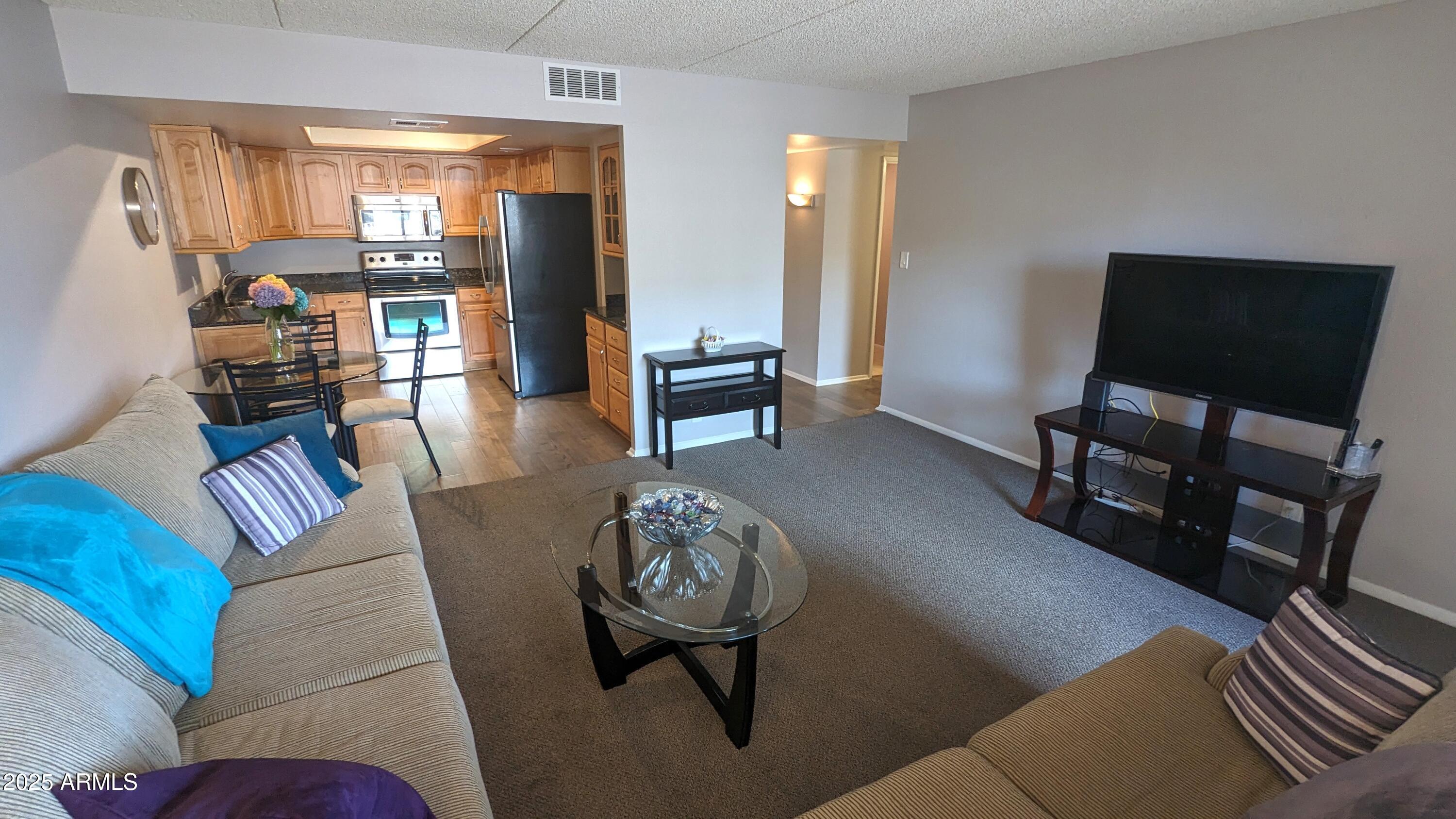 7910 East Camelback Road, Unit 302 Scottsdale, AZ 85251 - Photo 6 of 26 a living room with furniture and a flat screen tv
