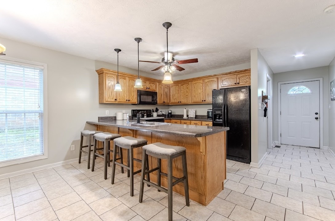310 Ping Hl Cove Counce, TN 38326 - Photo 12 of 43 a kitchen with stainless steel appliances granite countertop a refrigerator a sink a stove and a dining table with white cabinets