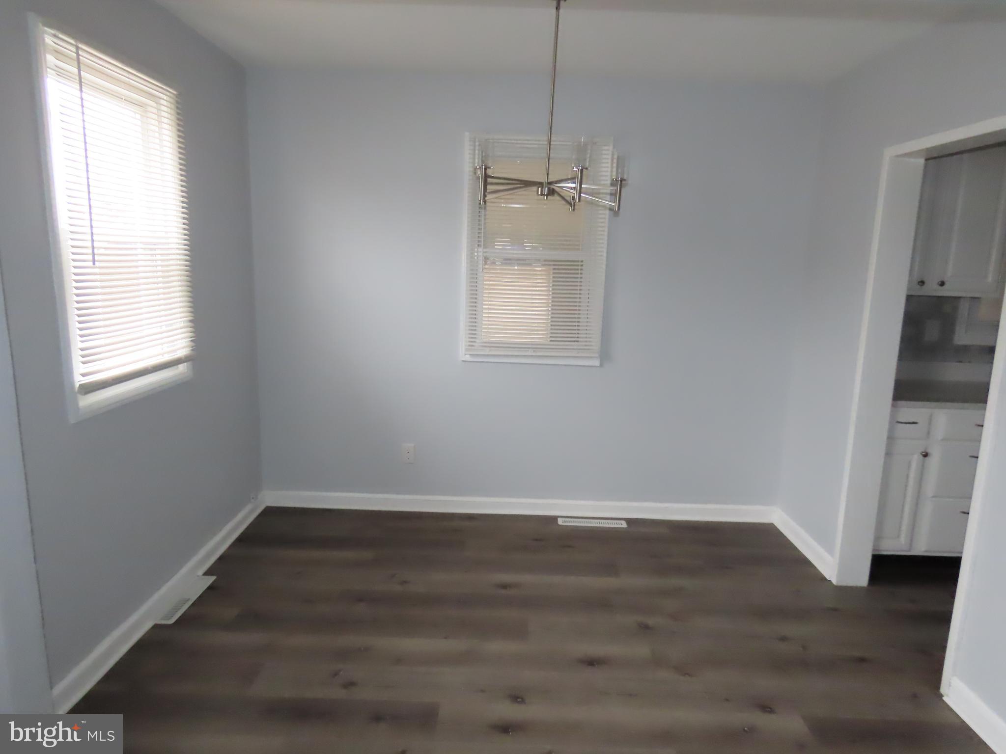 110 Robinson Drive New Castle, DE 19720 - Photo 3 of 10 a view of an empty room with wooden floor and a window
