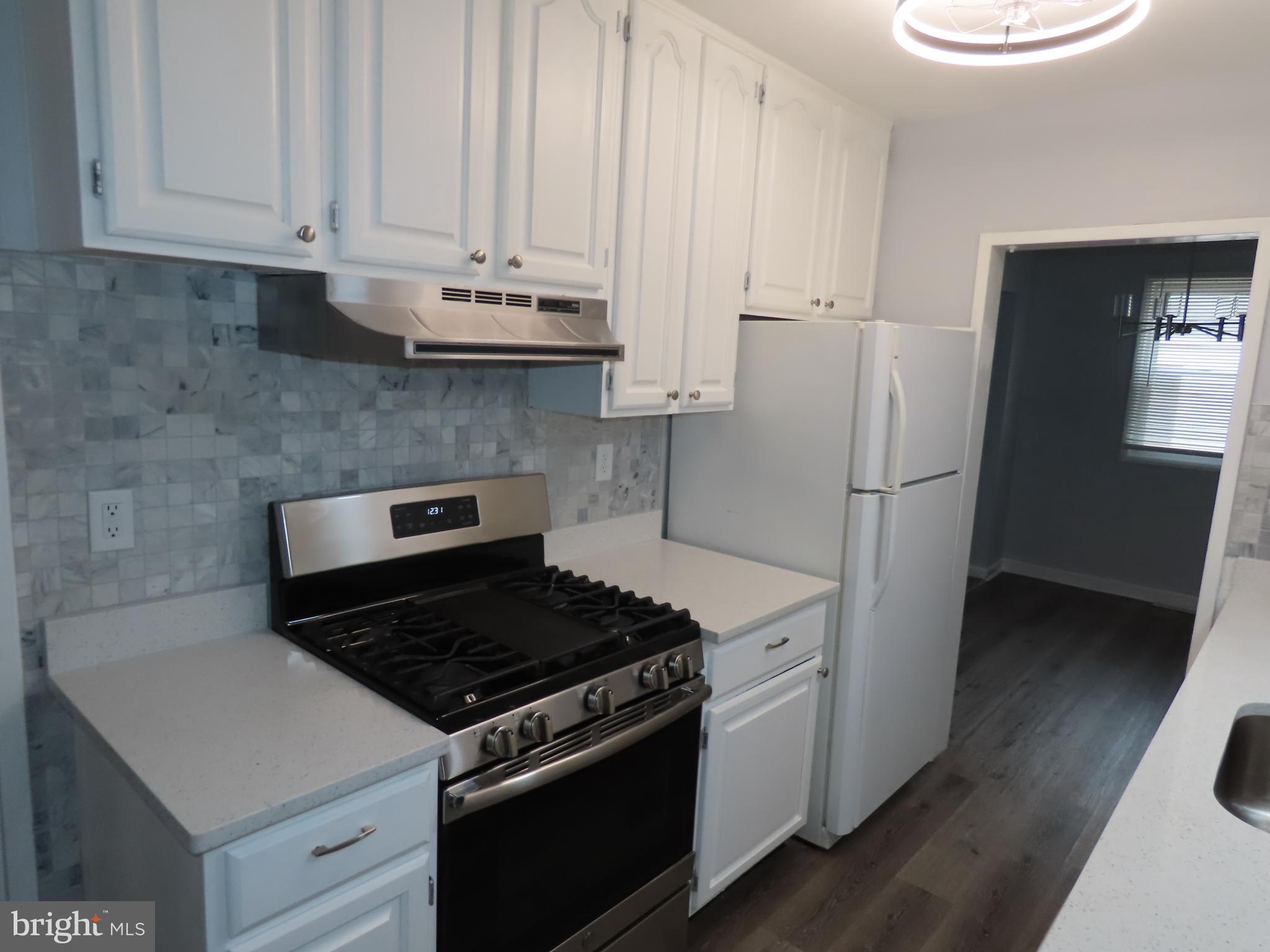 110 Robinson Drive New Castle, DE 19720 - Photo 4 of 10 a kitchen with white cabinets and white appliances