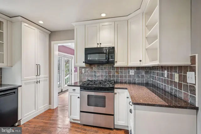 a kitchen with stainless steel appliances granite countertop a refrigerator stove and sink