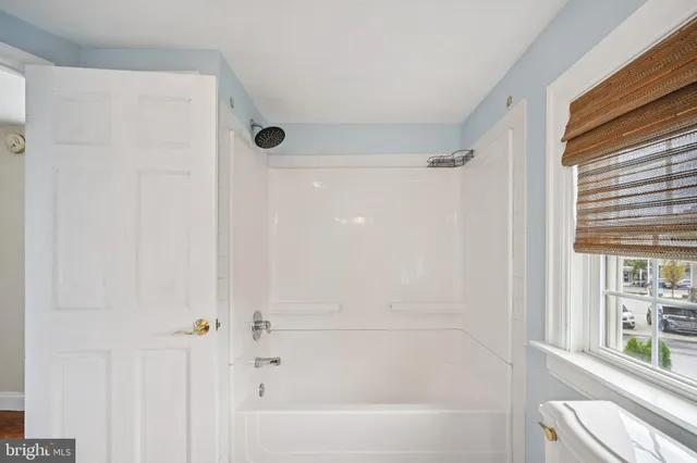 a bathroom with a toilet a sink a tub and mirror