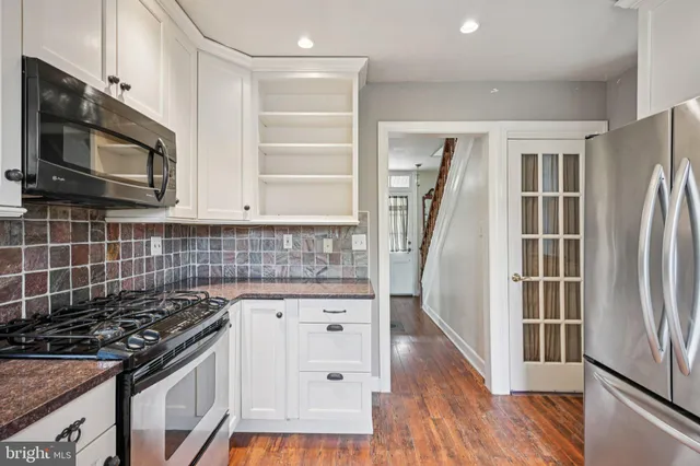 a kitchen with granite countertop a stove sink and microwave