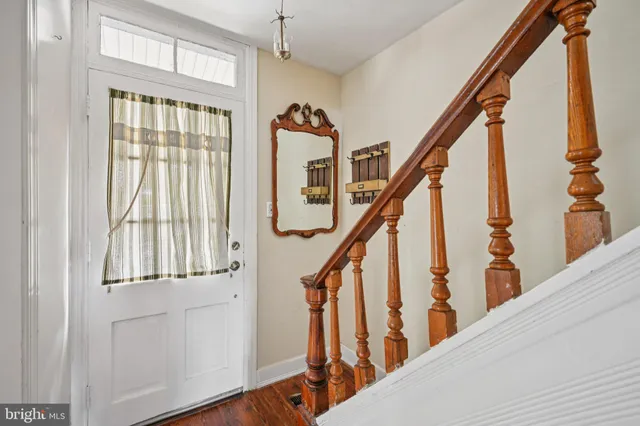 a view of a hallway with wooden floor and staircase