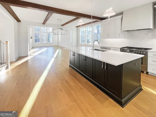 a kitchen with a sink cabinets and wooden floor