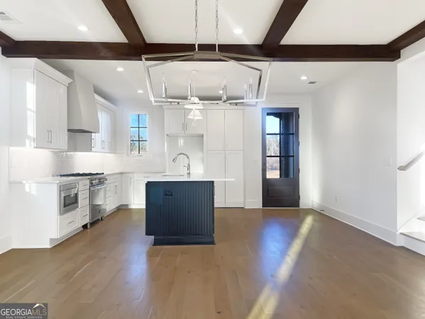 a kitchen with stainless steel appliances kitchen island wooden floors and view living room