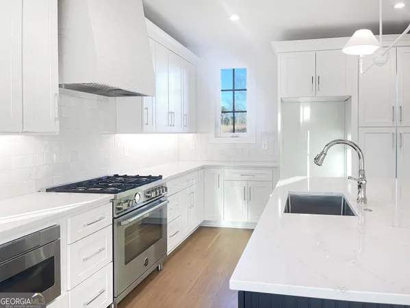 a kitchen with granite countertop a sink stainless steel appliances and cabinets