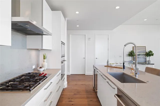 a kitchen with kitchen island granite countertop a stove and a sink