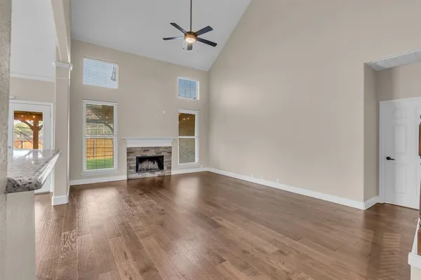 a view of empty room with fireplace and wooden floor