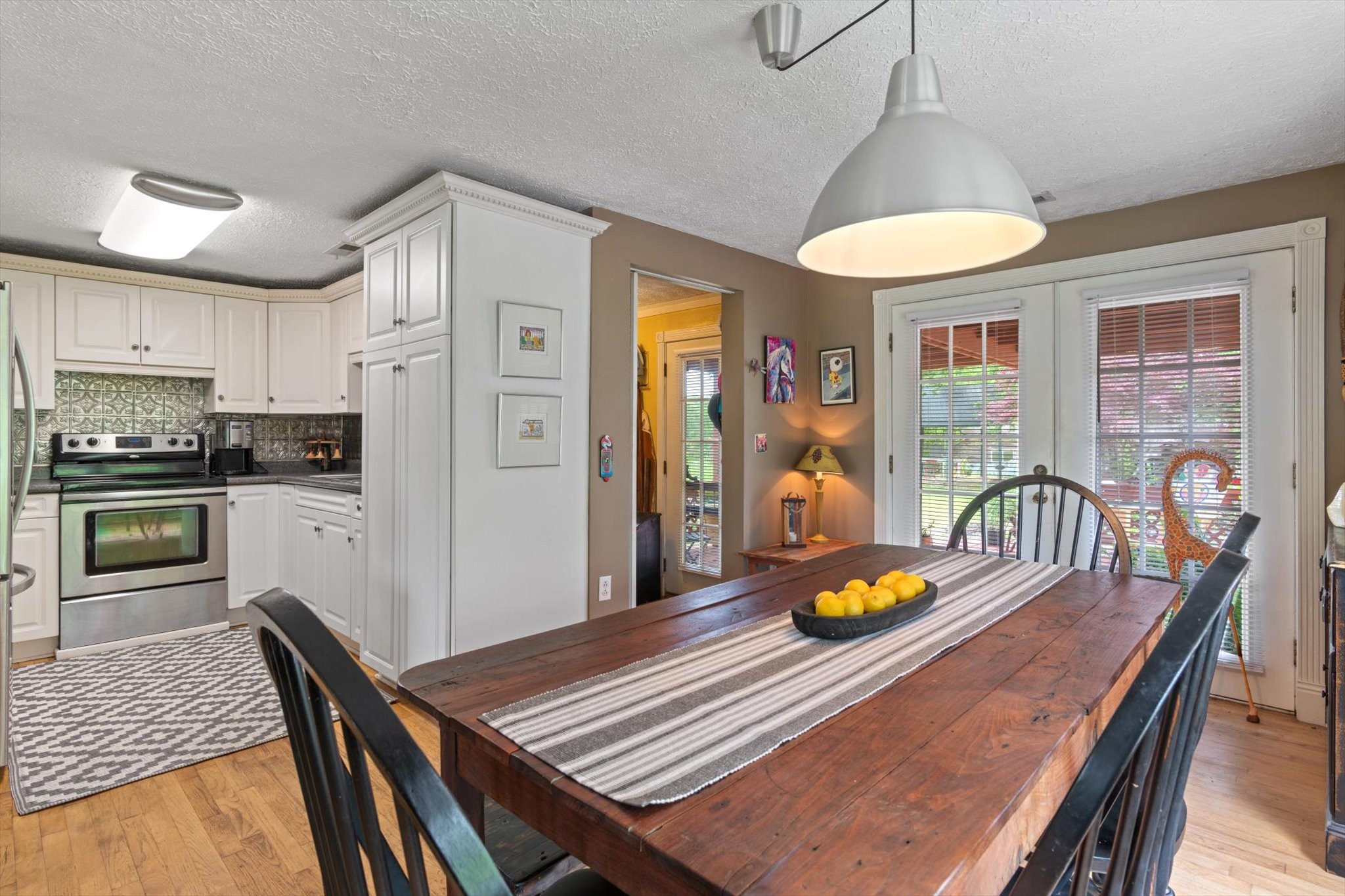 126 Blackey Bandy Road Bethpage, TN 37022 - Photo 9 of 37 a kitchen with stainless steel appliances granite countertop a refrigerator a stove a sink dishwasher a dining table and chairs with wooden floor