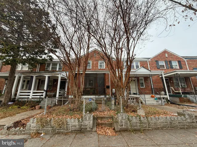 a front view of a house with a tree