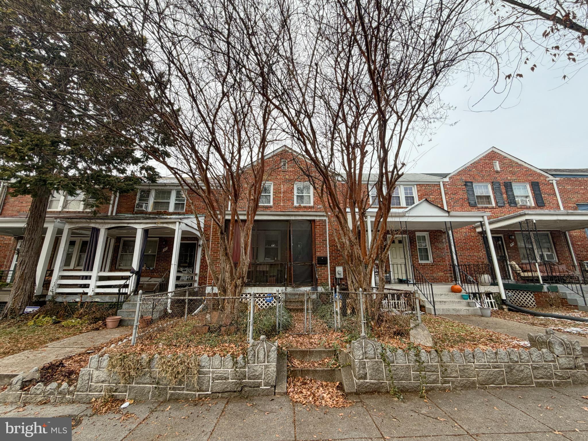 a front view of a house with a tree