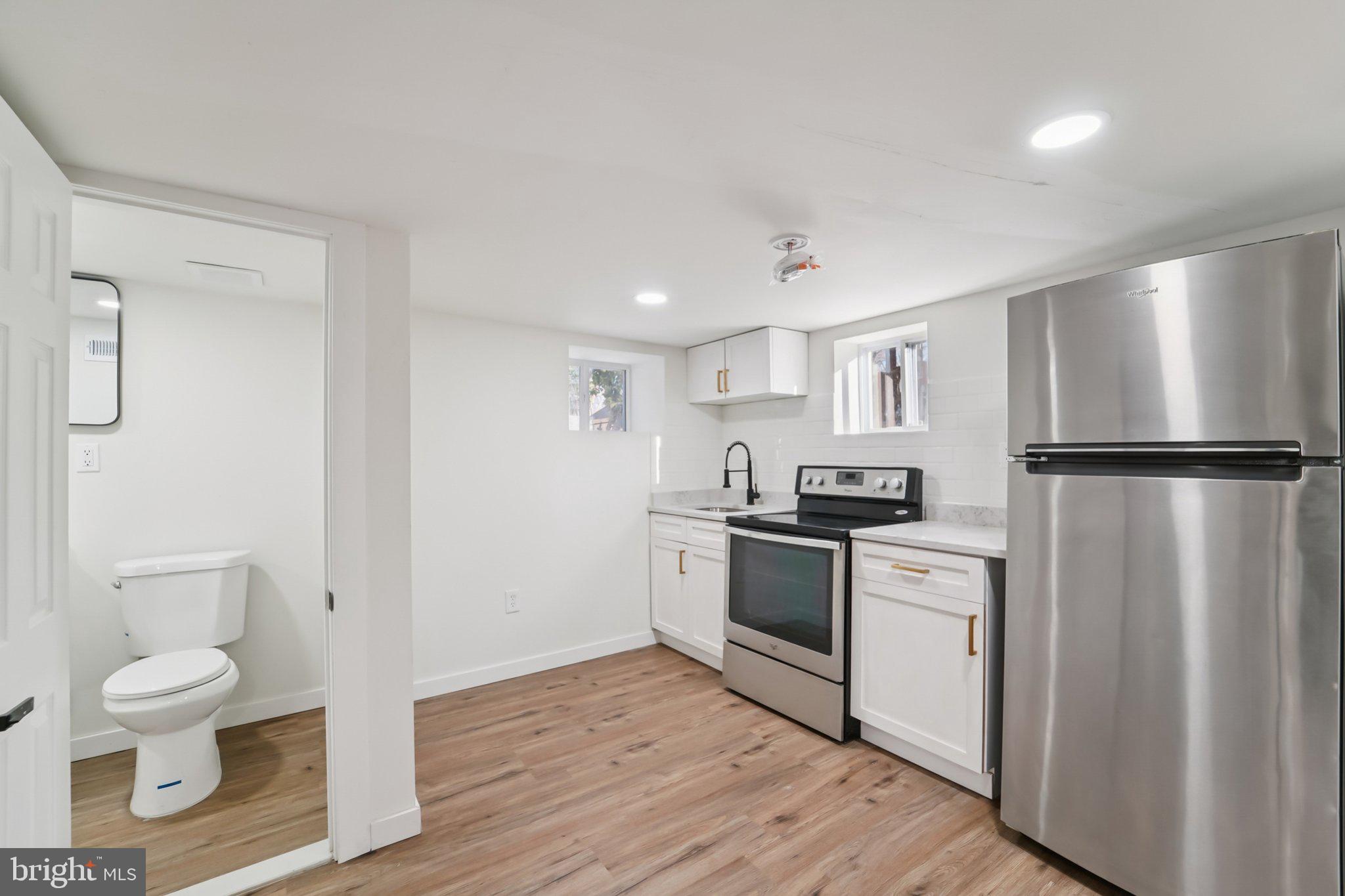 27 Pelczar Avenue Baltimore, MD 21221 - Photo 14 of 40 a kitchen with a refrigerator sink and wooden floor