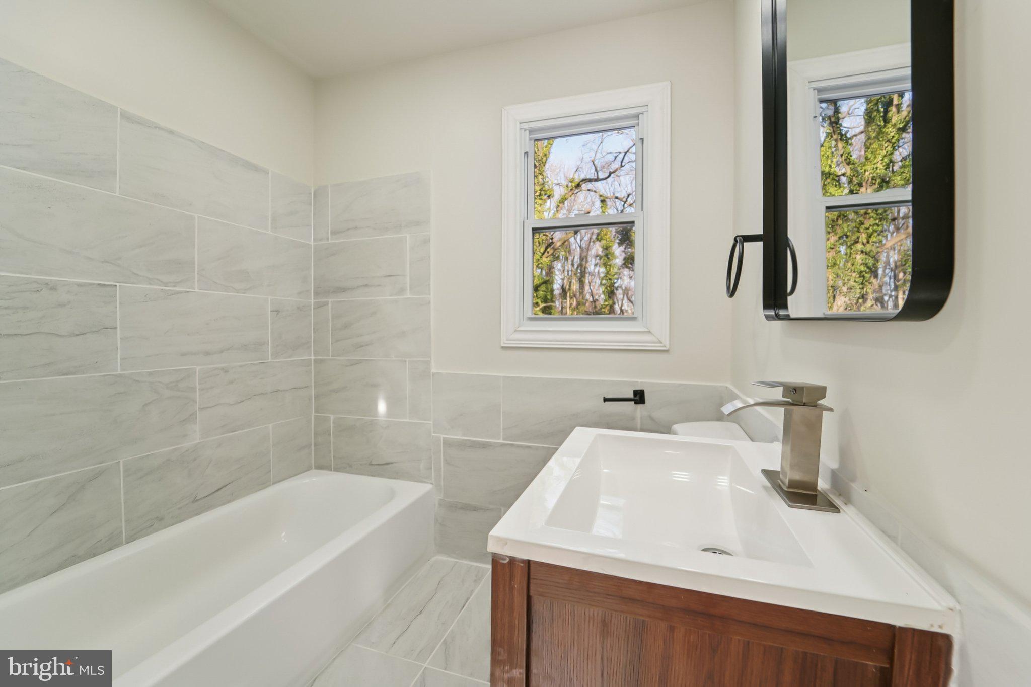 27 Pelczar Avenue Baltimore, MD 21221 - Photo 15 of 40 a bathroom with a sink a bathtub and a shower