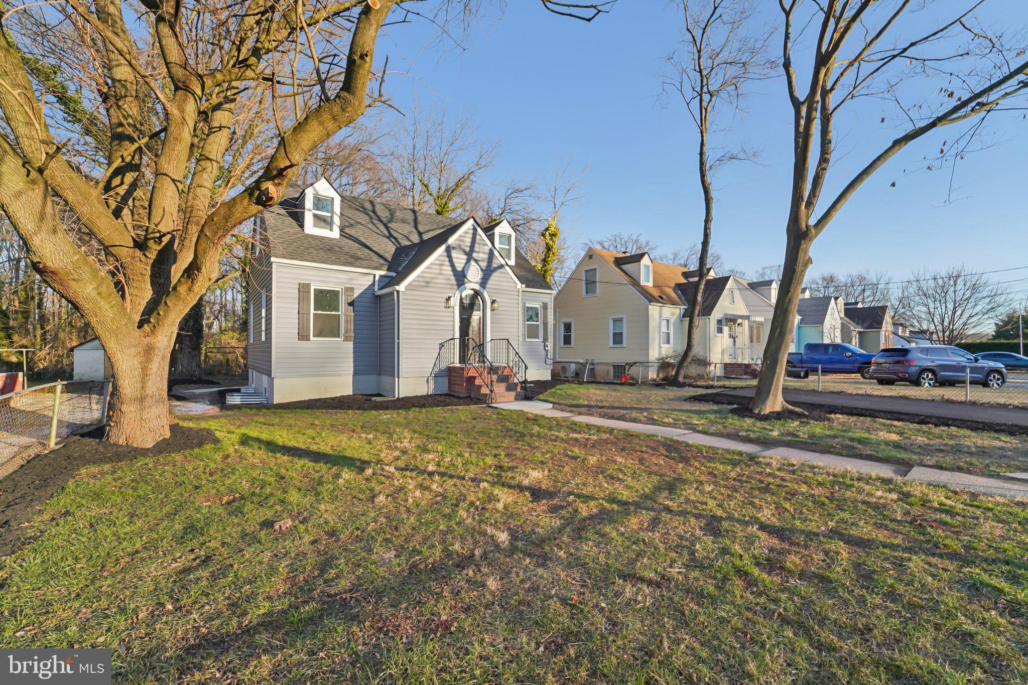 27 Pelczar Avenue Baltimore, MD 21221 - Photo 5 of 40 a view of a white house next to a yard with large trees