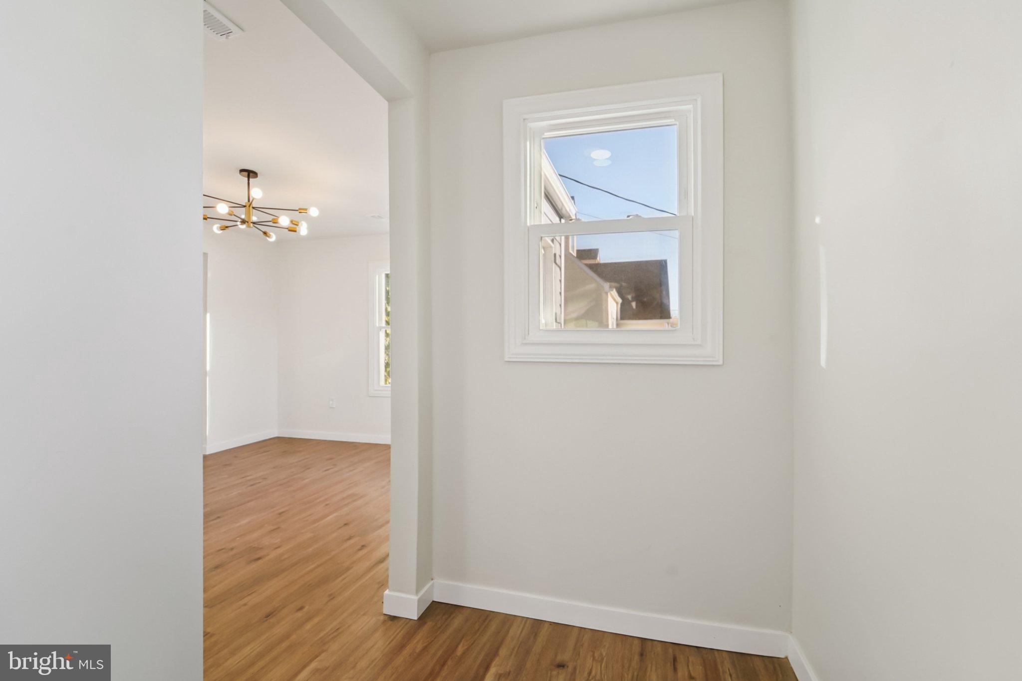 27 Pelczar Avenue Baltimore, MD 21221 - Photo 7 of 40 an empty room with wooden floor and a bathroom