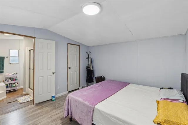 a bedroom with a bed and wooden floor