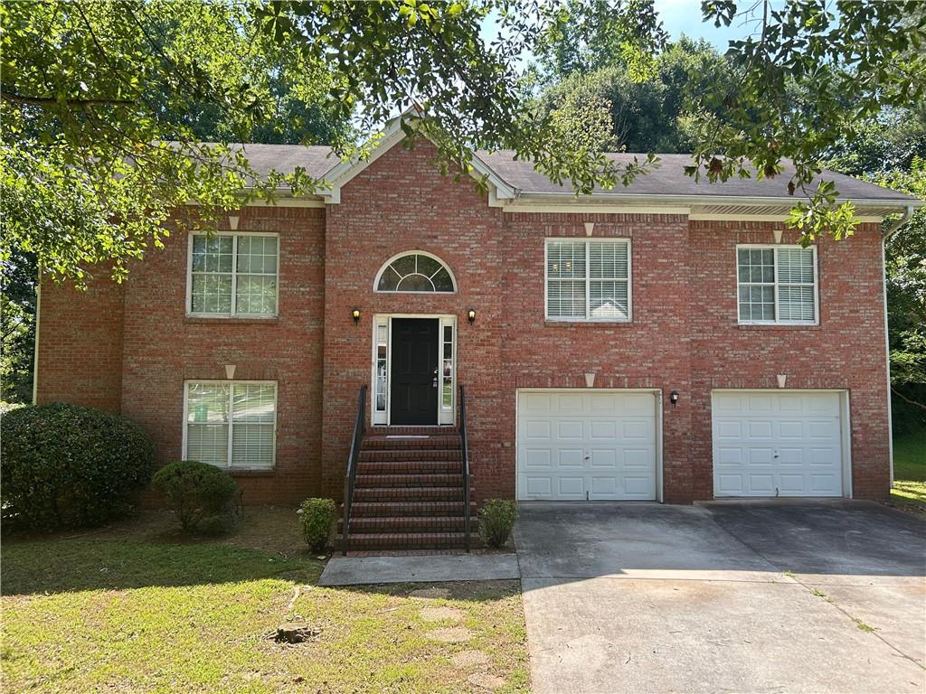 5975 Arbor Links Road Lithonia, GA 30058 - Photo 1 of 1 a front view of a house with a yard and garage