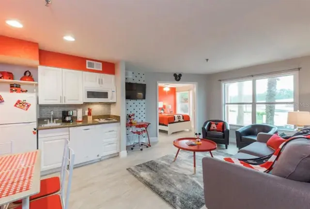 a living room with furniture a flat screen tv and a window