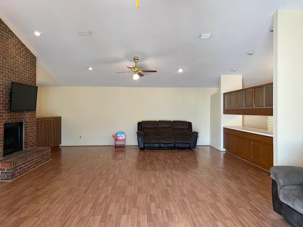 a view of a livingroom with workspace and a ceiling fan