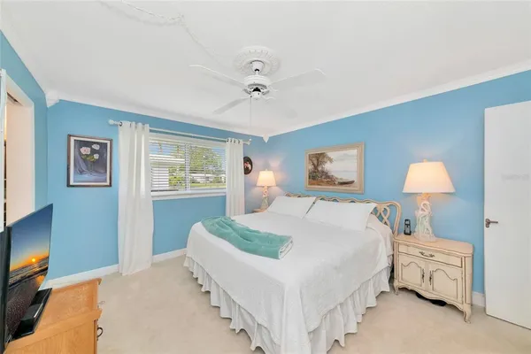 a bedroom with a bed and a lamp on dresser