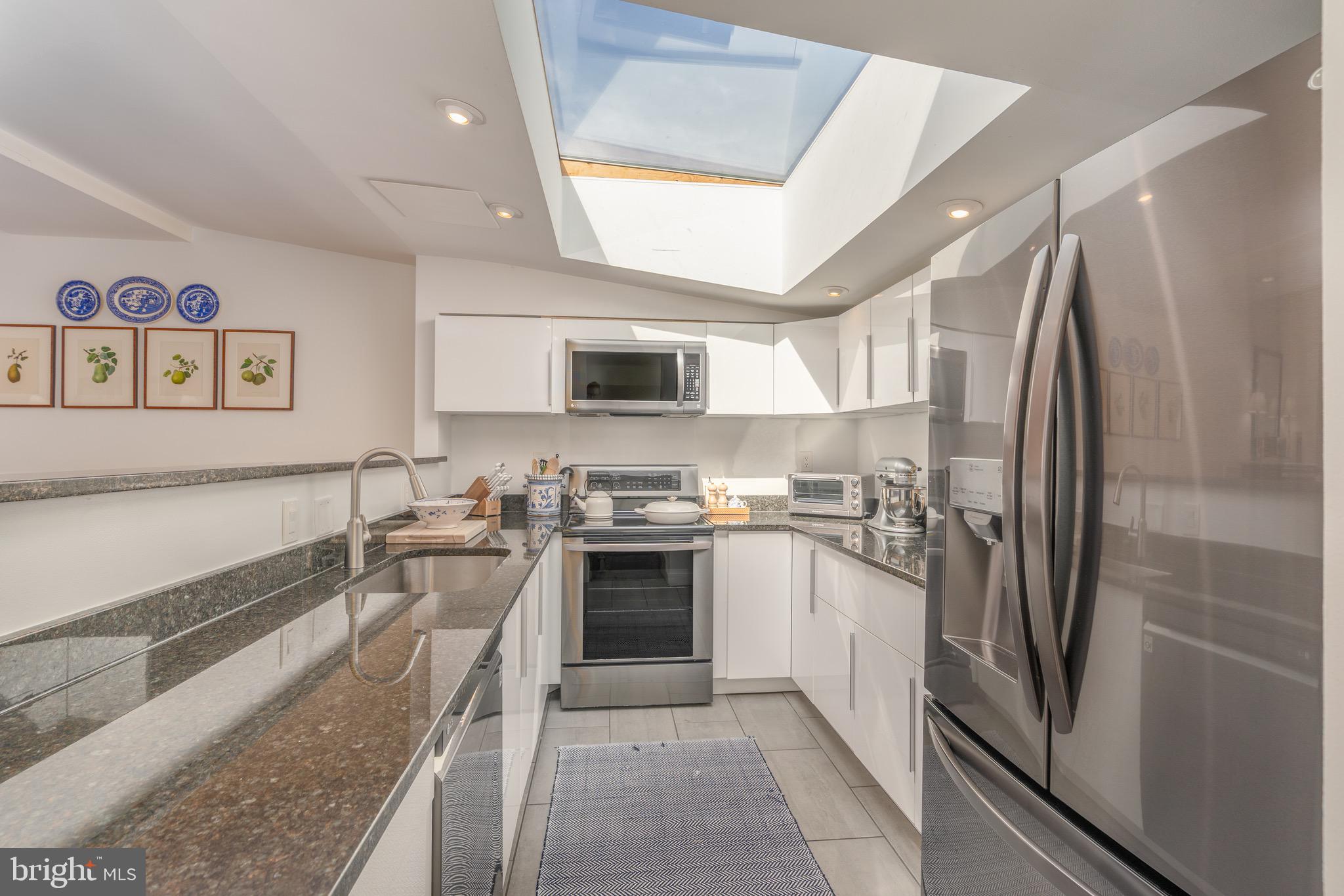 2115 S Street Northwest, Unit 3A Washington, DC 20008 - Photo 9 of 26 a kitchen with stainless steel appliances granite countertop a refrigerator a stove top oven a sink and dishwasher