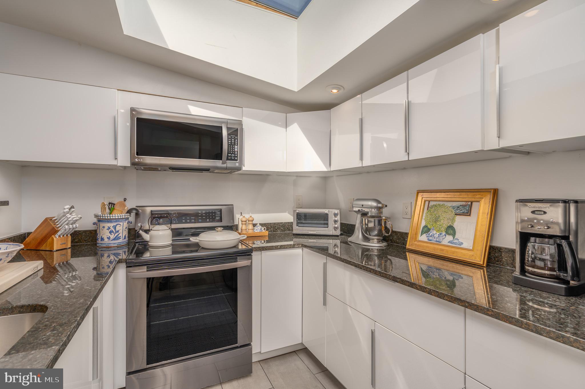 2115 S Street Northwest, Unit 3A Washington, DC 20008 - Photo 10 of 26 a kitchen with stainless steel appliances granite countertop a stove sink microwave and cabinets