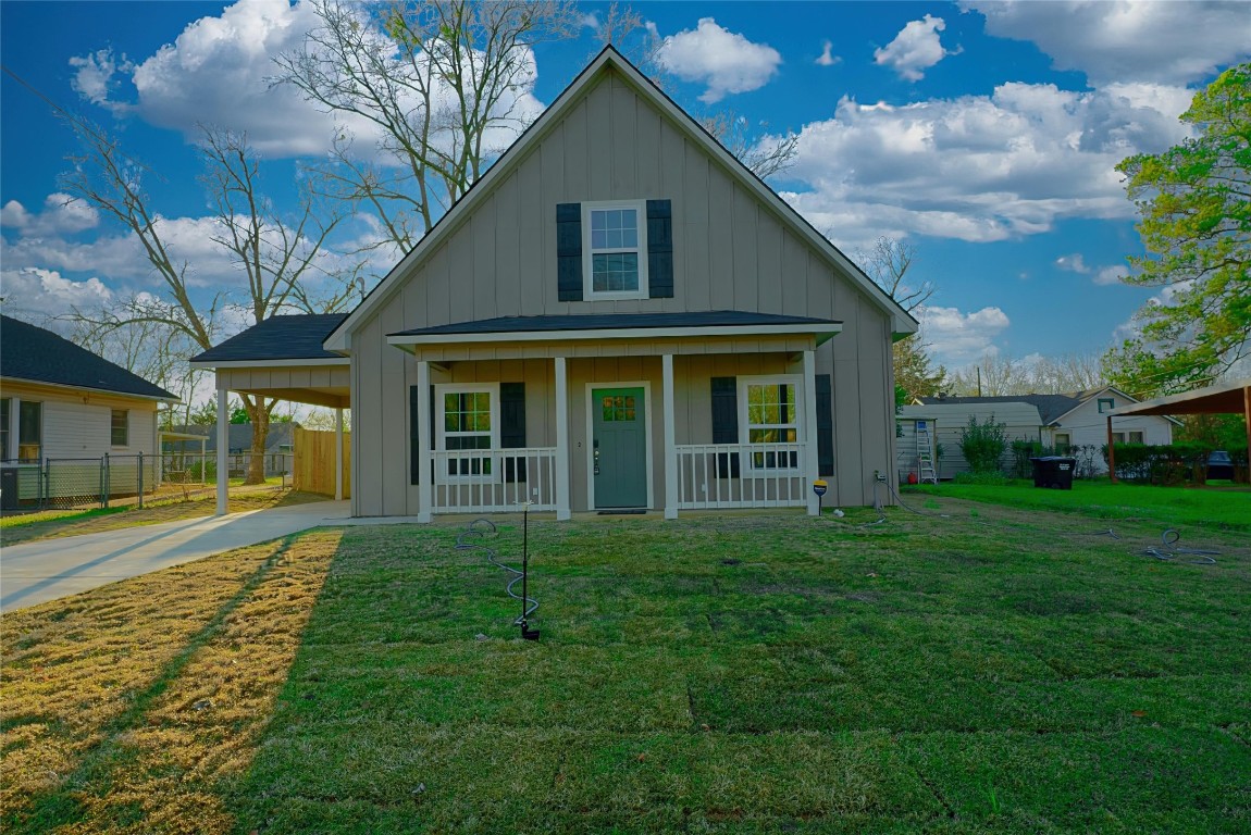 a view of a yard in front of a house with a large tree