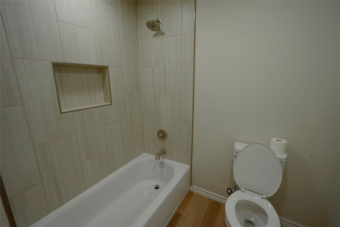 233 Harrison Street Longview, TX 75601 - Photo 11 of 24 a bathroom with a toilet and a bathtub