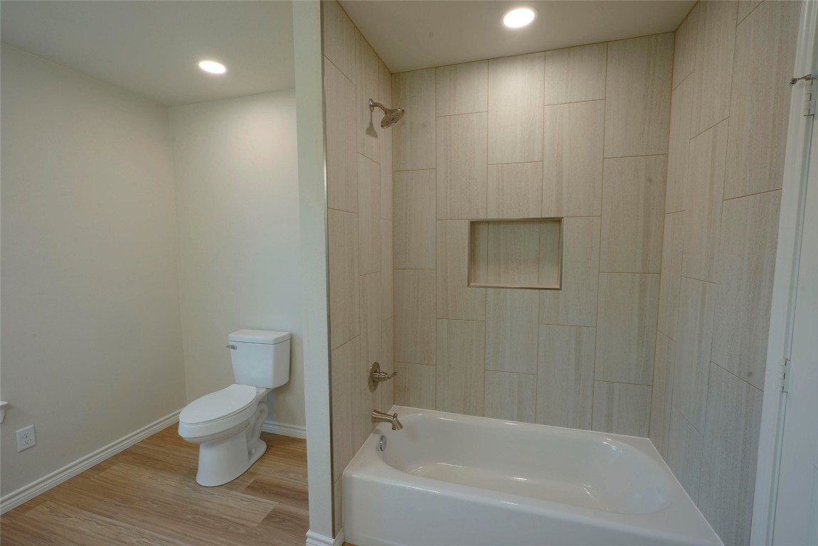 233 Harrison Street Longview, TX 75601 - Photo 19 of 24 a bathroom with a toilet and a bathtub