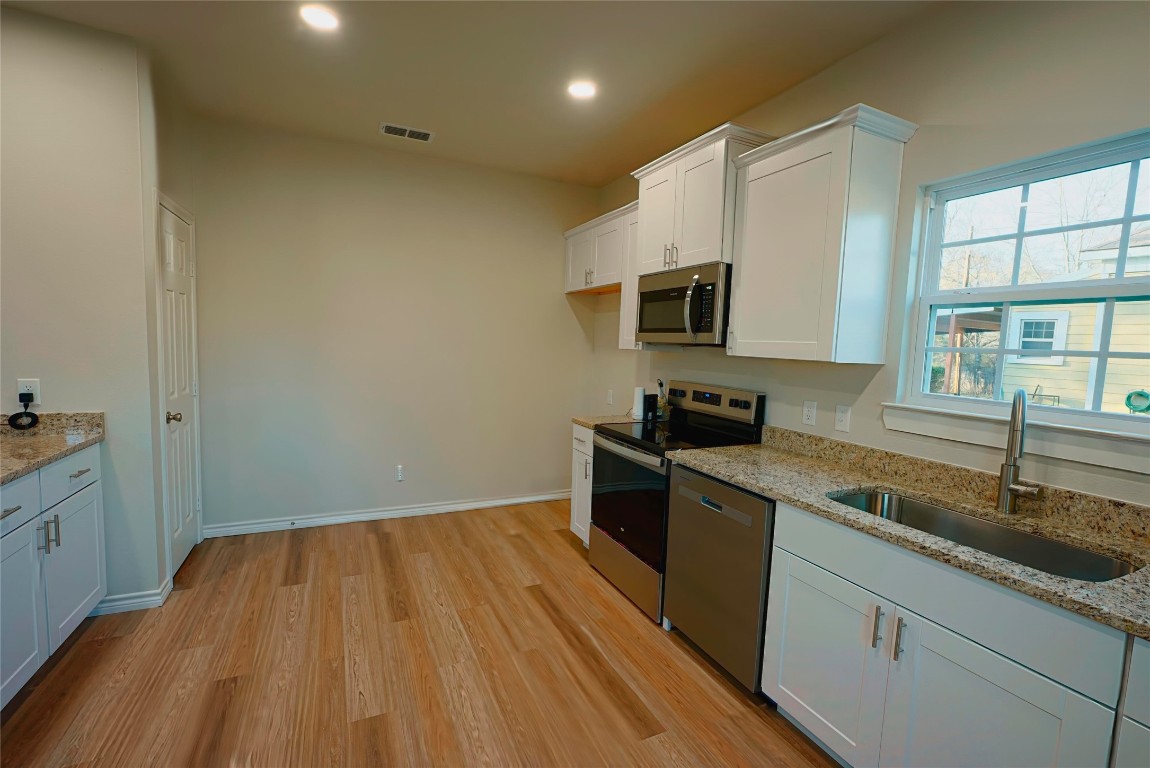 233 Harrison Street Longview, TX 75601 - Photo 6 of 24 a kitchen with a sink a microwave a stove and refrigerator