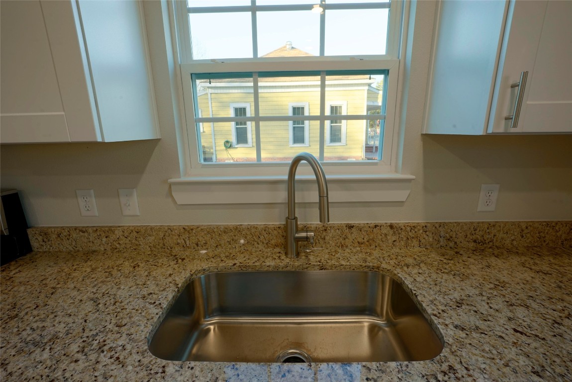 233 Harrison Street Longview, TX 75601 - Photo 7 of 24 a kitchen with granite countertop a sink and a window