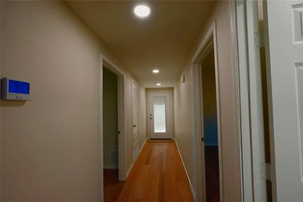 a view of a hallway with wooden floor