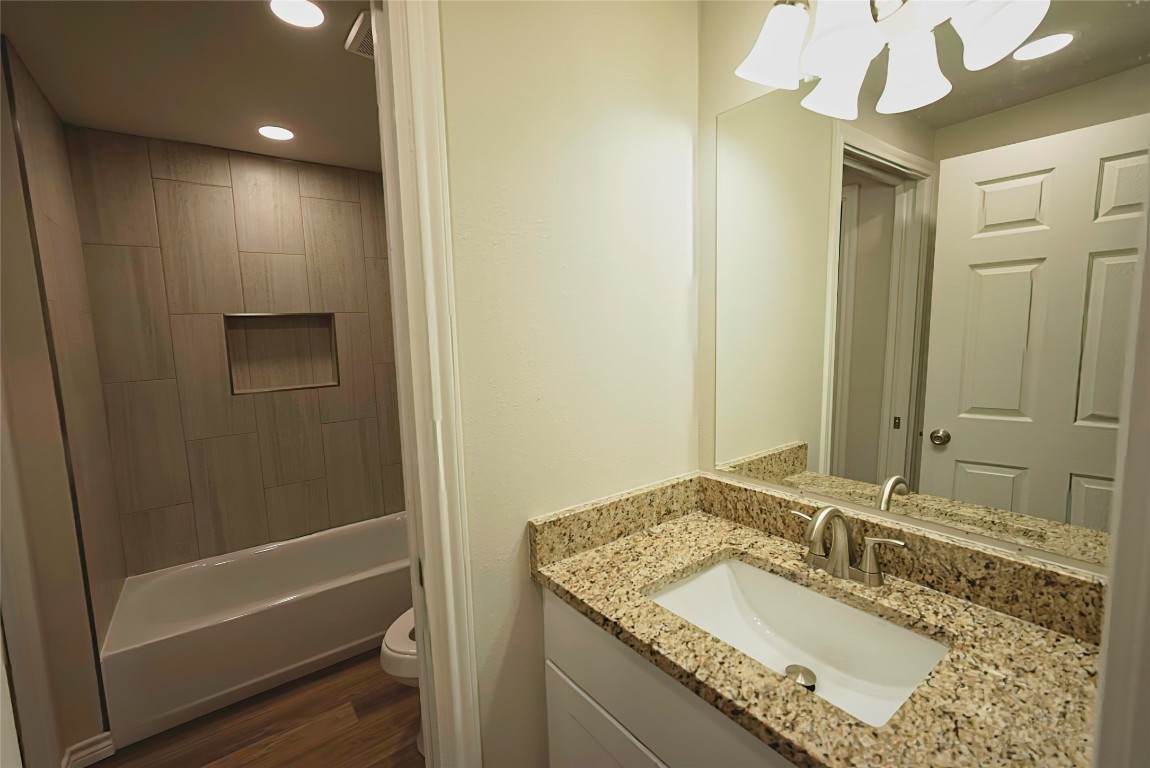 233 Harrison Street Longview, TX 75601 - Photo 10 of 24 a bathroom with a granite countertop sink a mirror and a shower