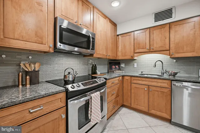 a kitchen with stainless steel appliances granite countertop a sink stove and microwave