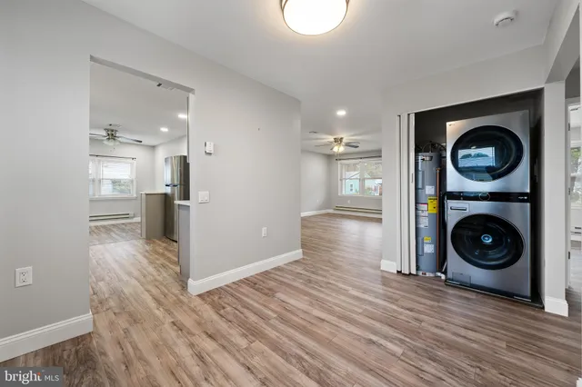 a view of a kitchen with a stove wooden cabinets and wooden floor