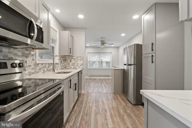 a kitchen with stainless steel appliances granite countertop a stove a refrigerator and a microwave