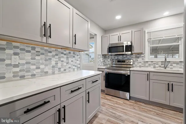 a kitchen with granite countertop cabinets stainless steel appliances and a sink