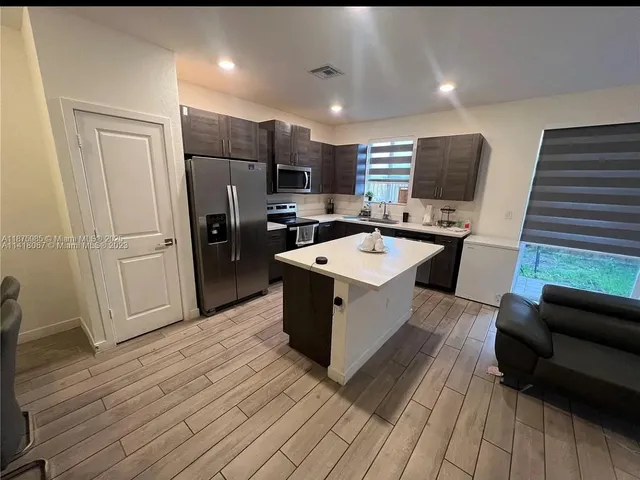 a large white kitchen with wooden floor